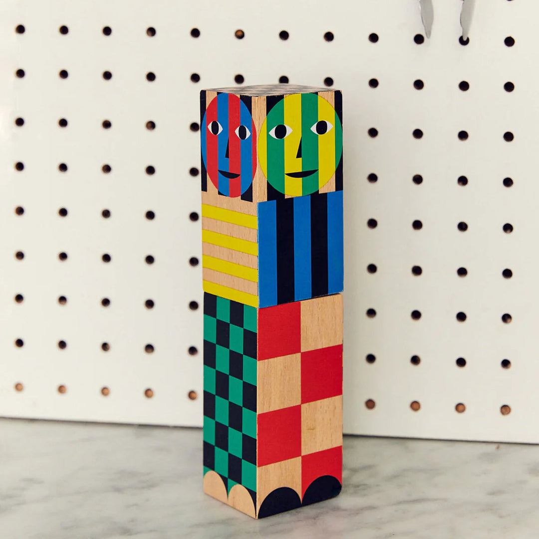 Colorful geometric block sculpture against a pegboard background