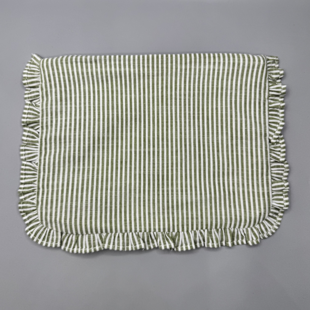 Green and white striped fabric with ruffled edges on a gray background