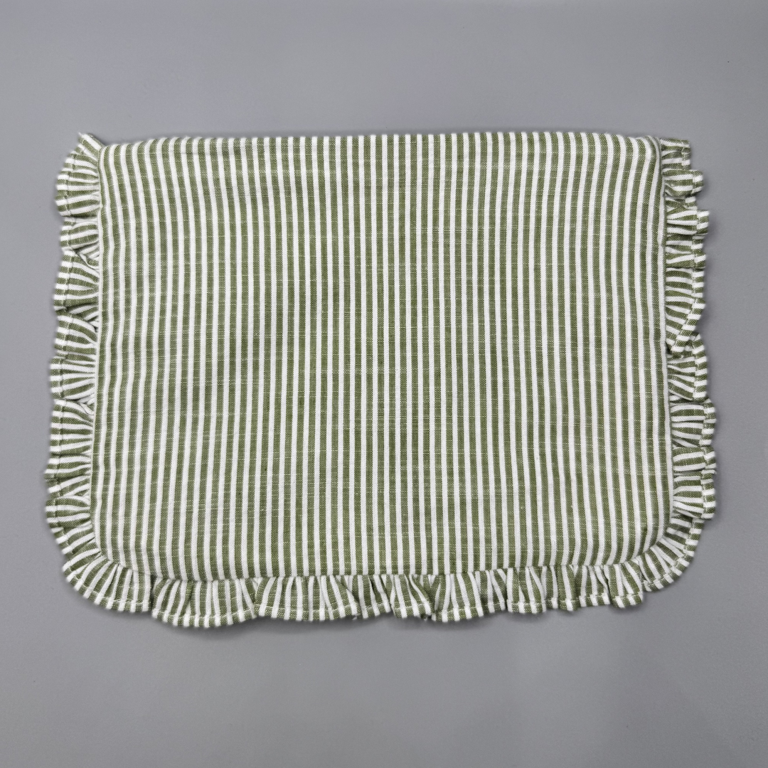 Green and white striped fabric with ruffled edges on a gray background