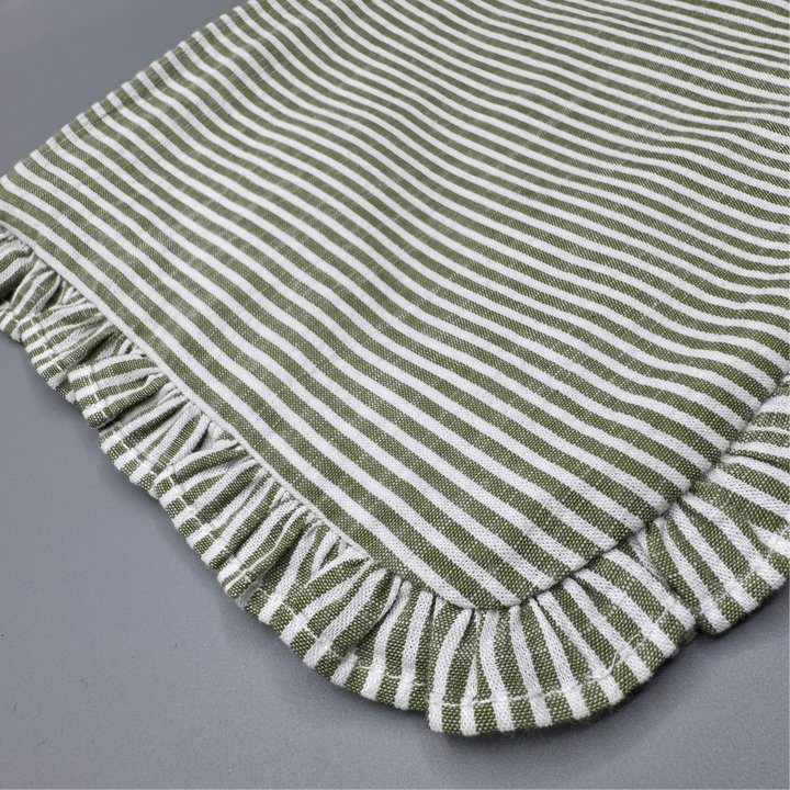 Green and white striped fabric with a ruffled edge on a gray background