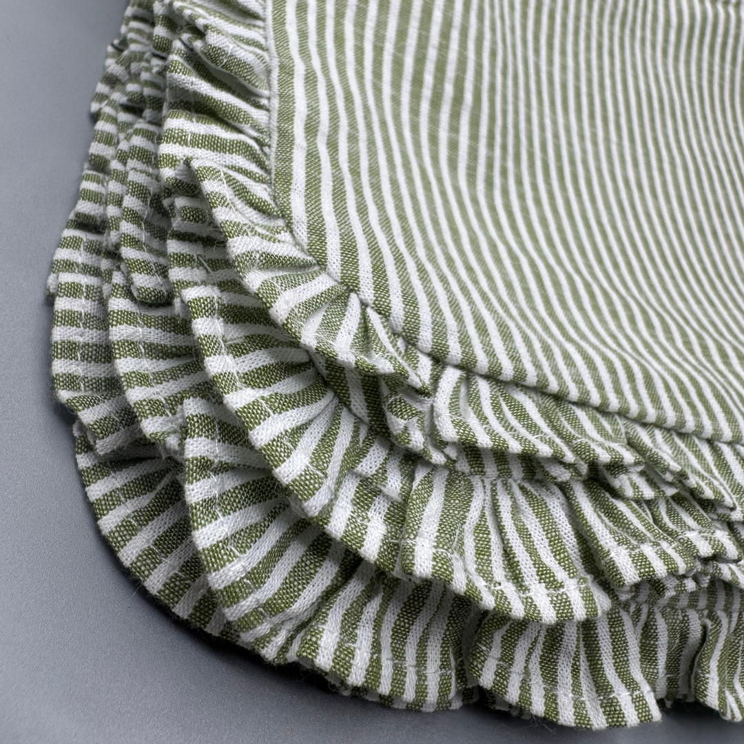 Folded green and white striped fabric on a gray background
