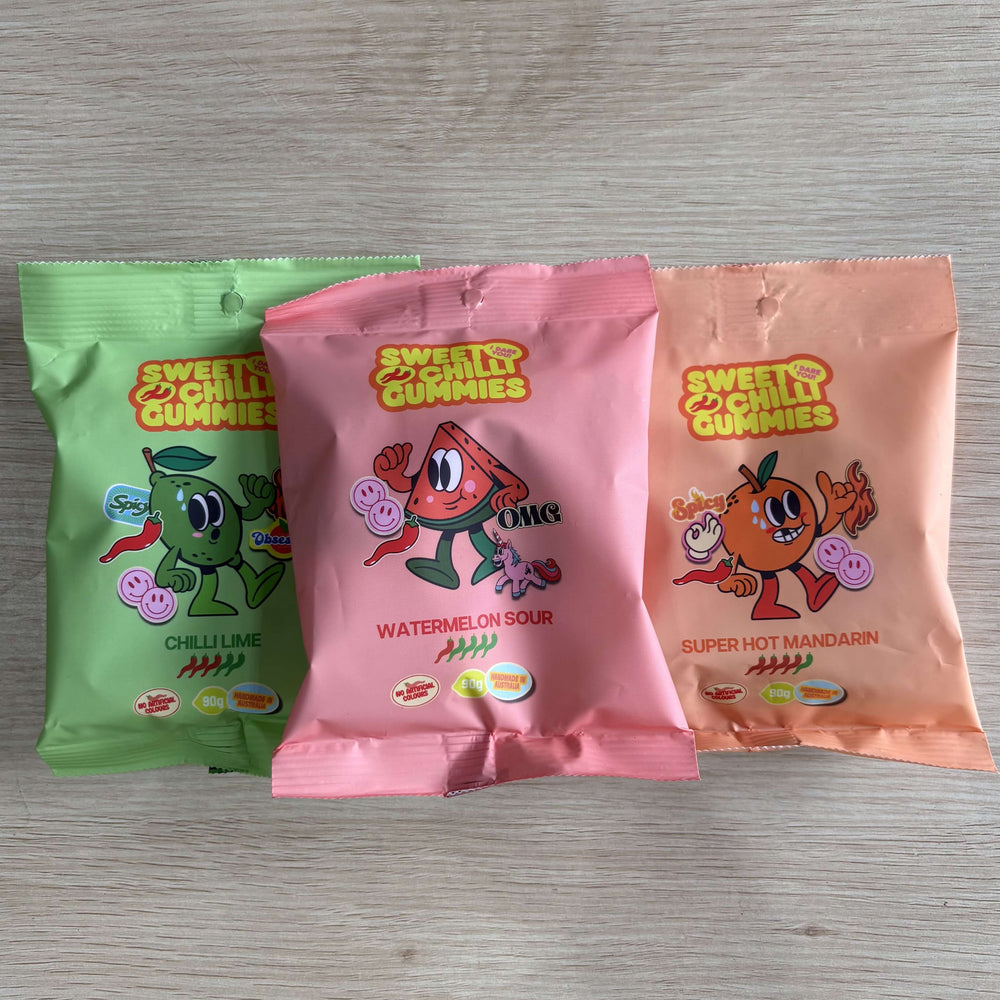Three packages of 'Sweet & Chilly Gummies' on a wooden surface