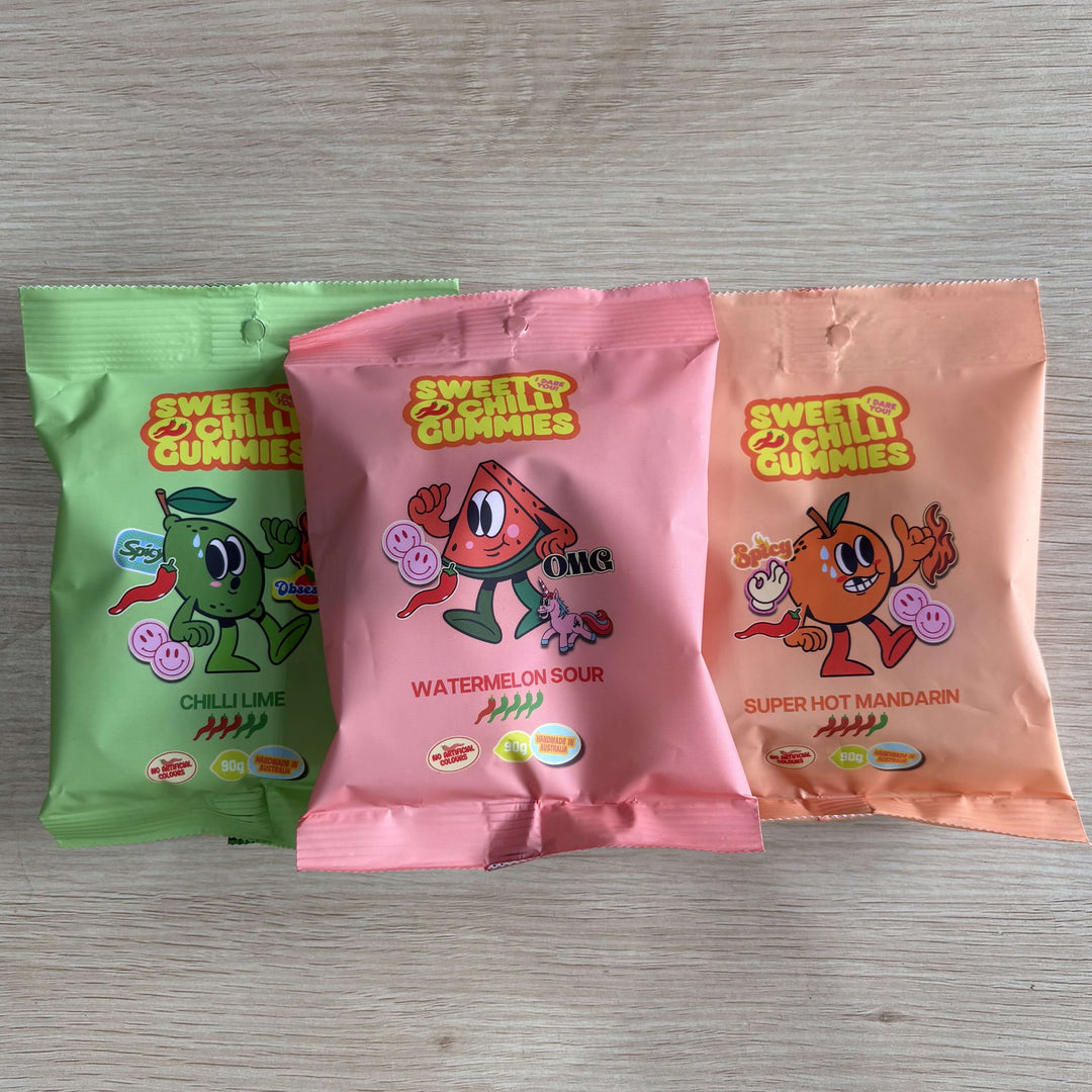 Three packages of 'Sweet & Chilly Gummies' on a wooden surface