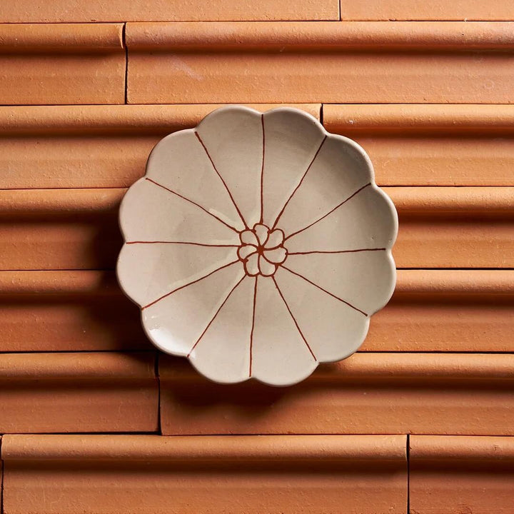 Ceramic flower-shaped dish on a wooden surface