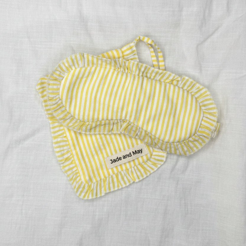 Yellow striped baby bibs on a light gray fabric background