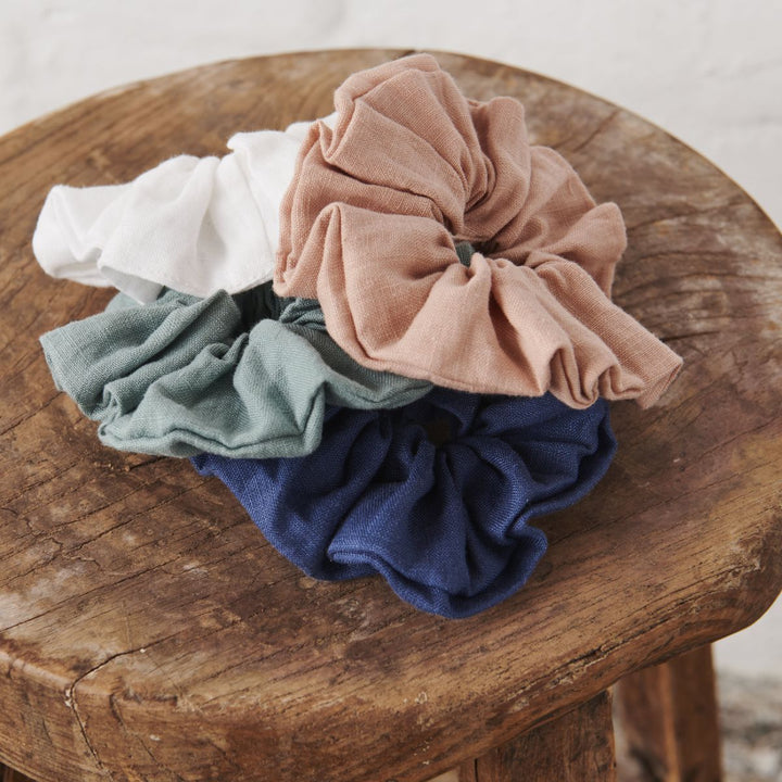 Linen Scrunchies sitting in a bundle on a wooden stool